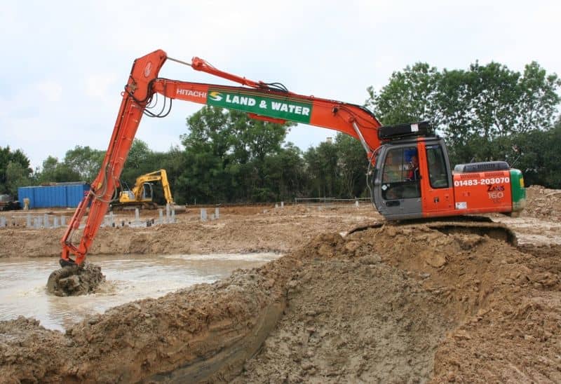 long reach excavator rental digging in water pool